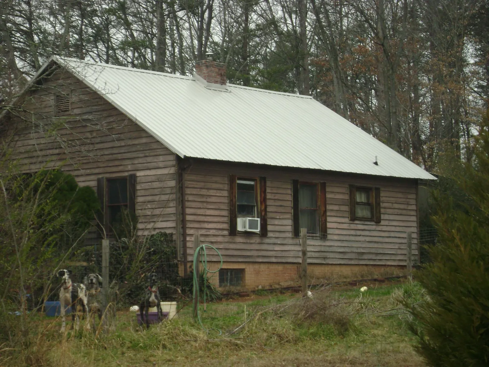 White metal roof on an old wood sided farmhouse, from a Metal Roof Installation job in Gaston